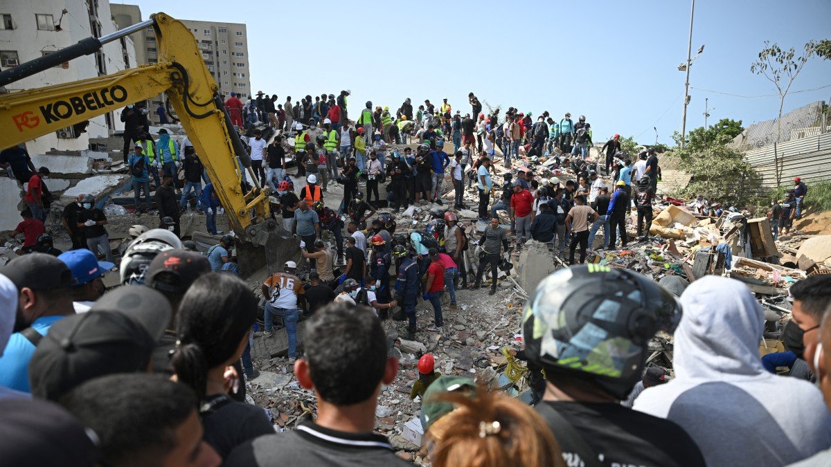 Rescue workers, volunteers, and residents search through the rubble of collapsed buildings in La Guaira