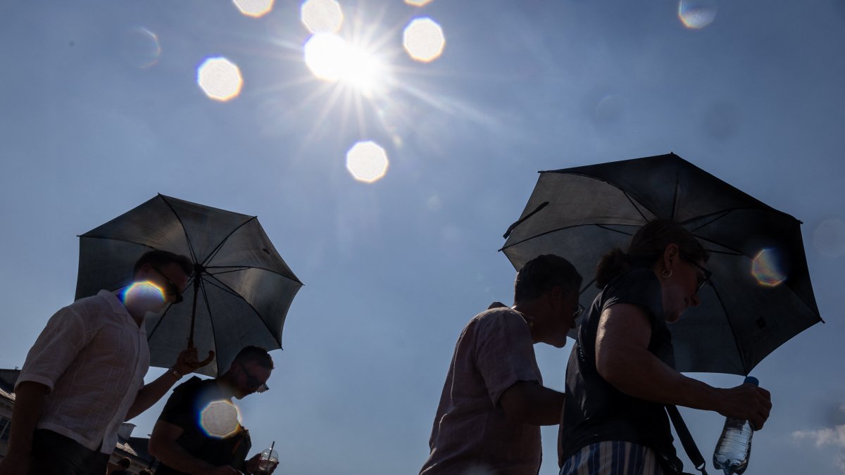 People seek shelter from the low sun in Warsaw, Poland.