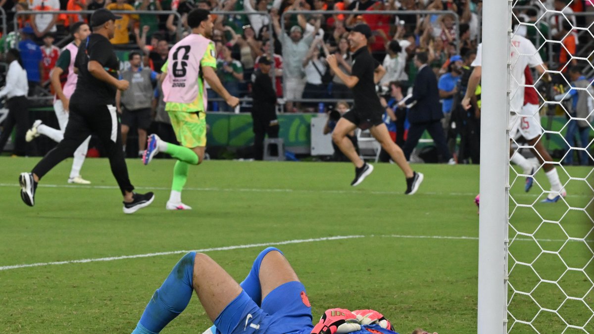 Dutch goalkeeper Verbruggen remains on the ground as the Moroccan players celebrate their victory