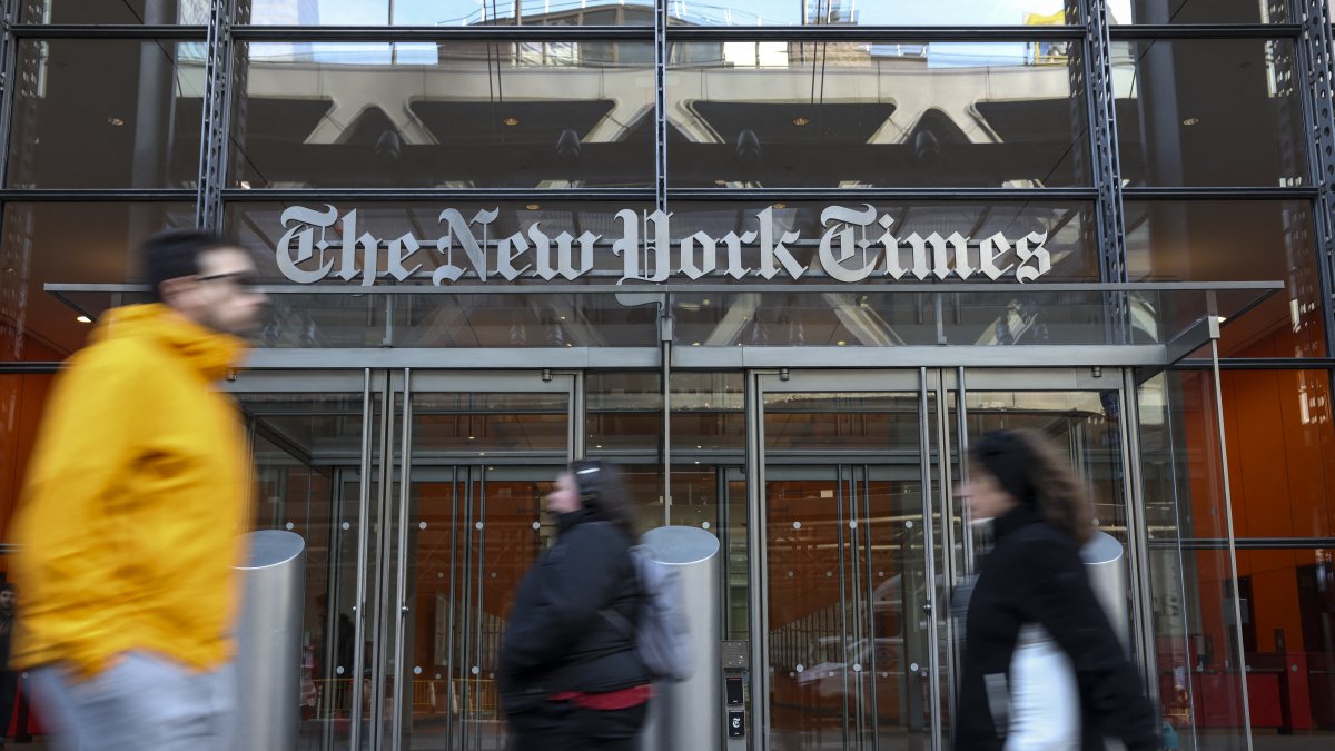 People walking past The New York Times' newsroom in New York