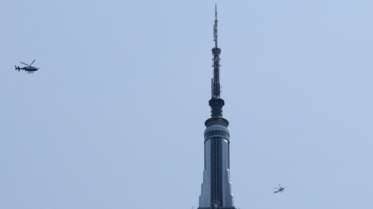 Two helicopters fly near the Empire State Building in New York on July 1, 2026