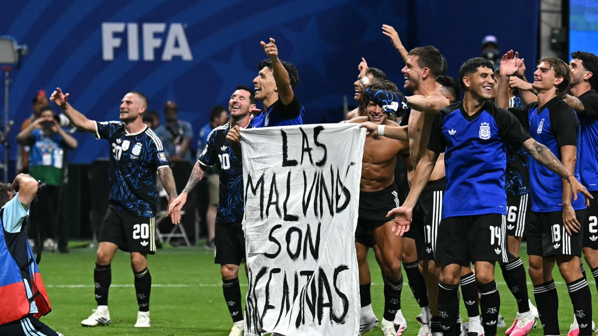 Argentine players hold a banner reading 