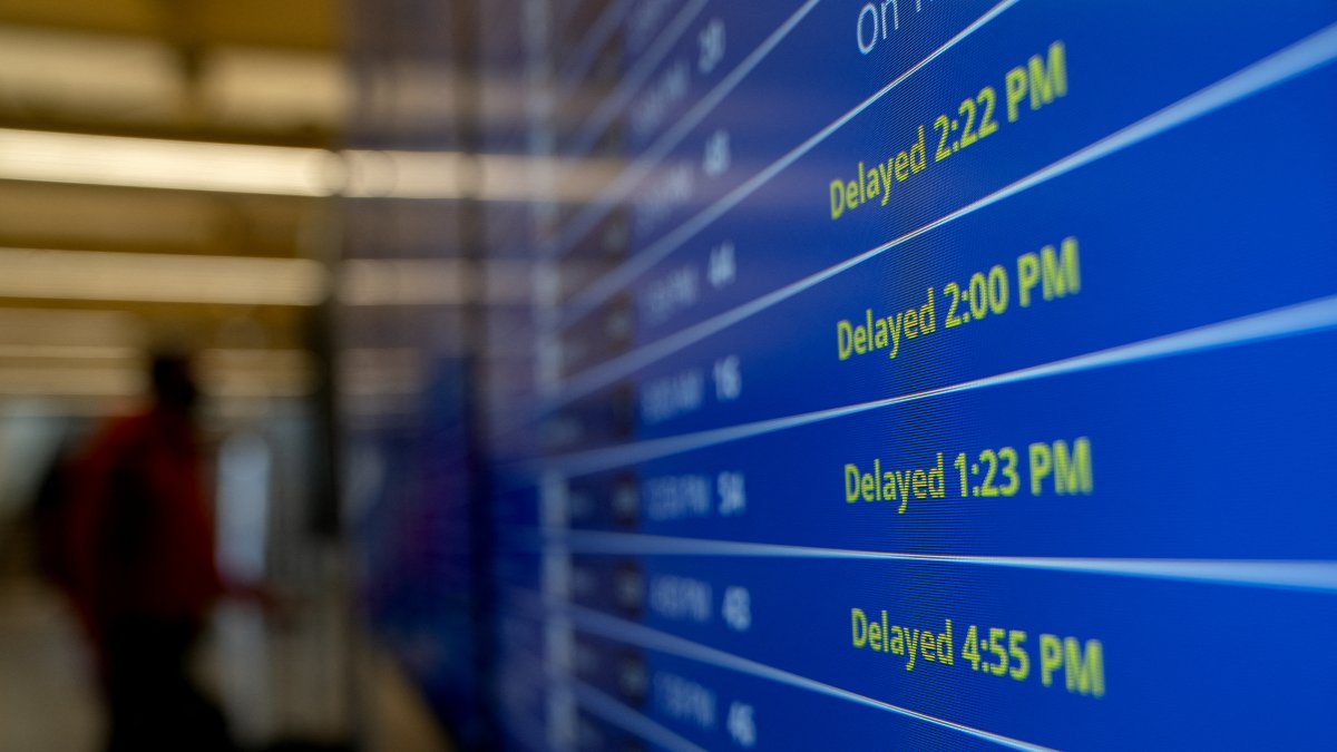 A screen at Ronald Reagan Washington National Airport displaying several delayed flights