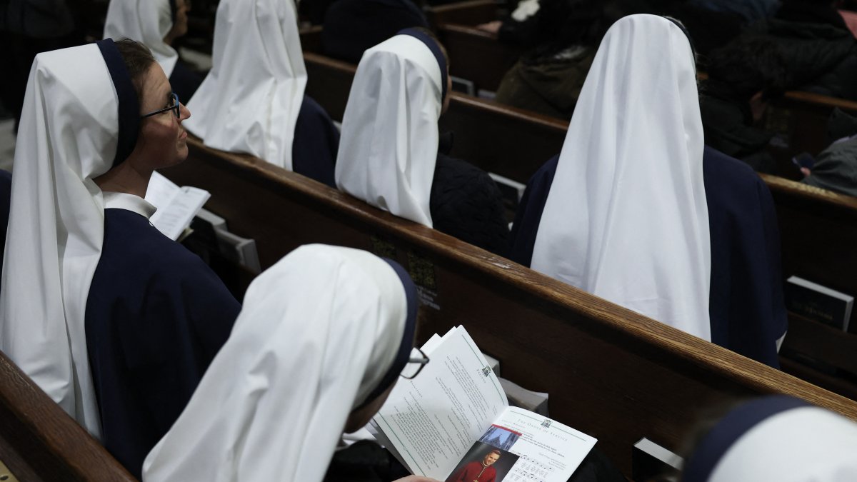 A nun looks through the program of the Solemn Vespers evening prayer at St. Patrick's Cathedral in New York