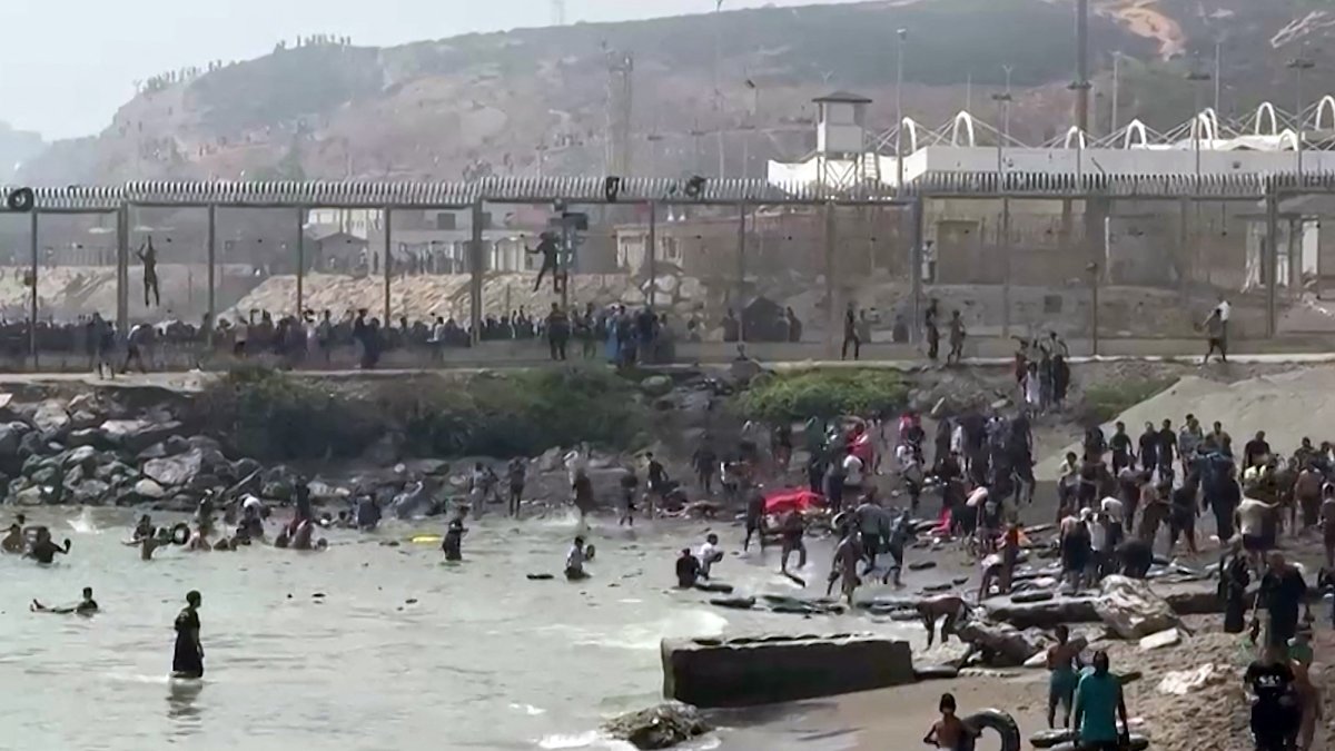 Migrants arriving on the coast of the Spanish enclave of Ceuta, in North Africa, after swimming around the border fence between Morocco and Spain on July 30, 2026.