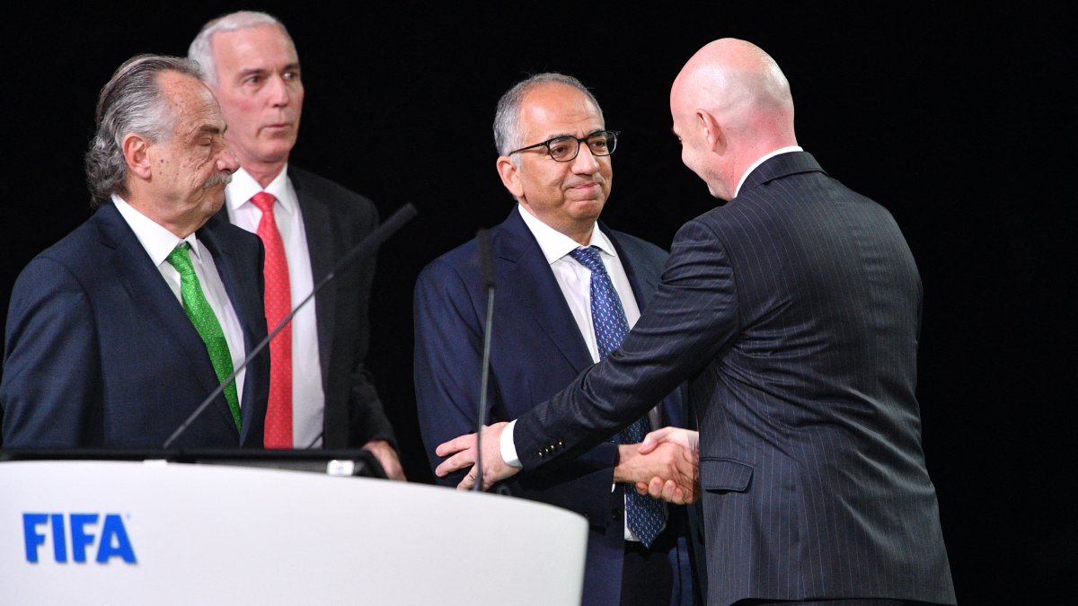Carlos Cordeiro shakes hands with Gianni Infantino during a FIFA assembly