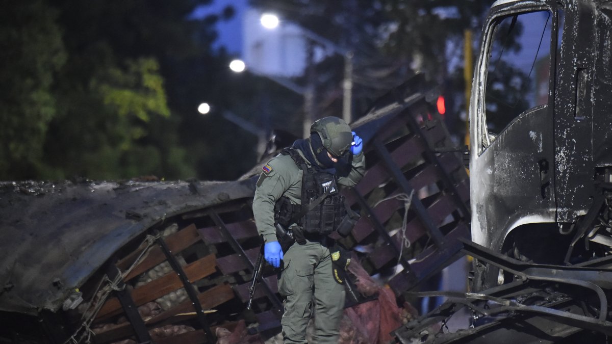 A police officer inspects the scene after a truck explosion