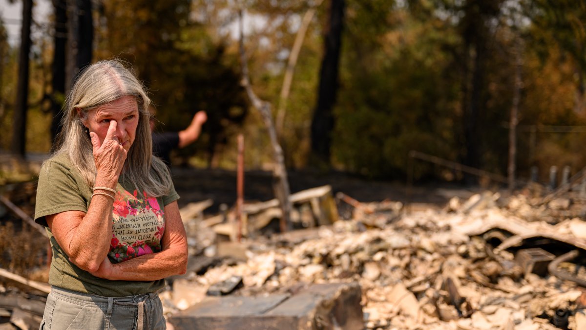 A woman looks at the remains of homes in Spokane