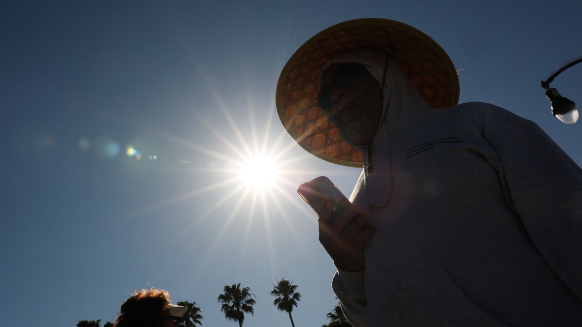 Una persona intenta cubrirse del sol en California