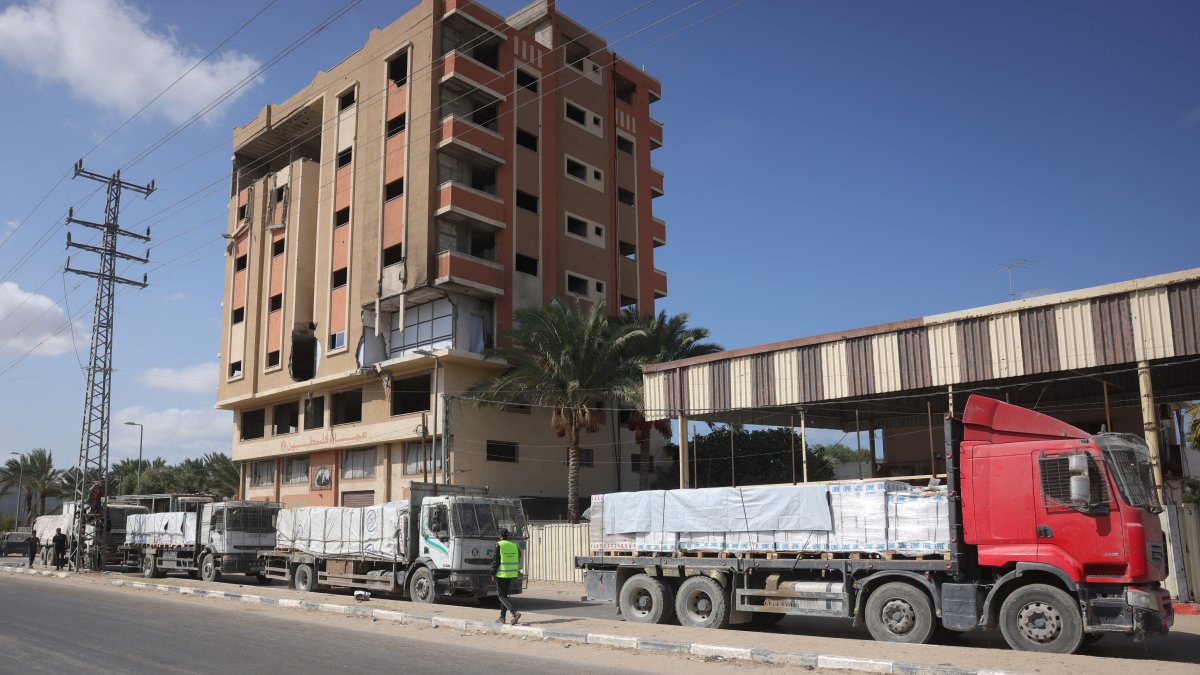 Trucks carrying aid provided by the World Food Programme (WFP) drive on a road in Deir el-Balah