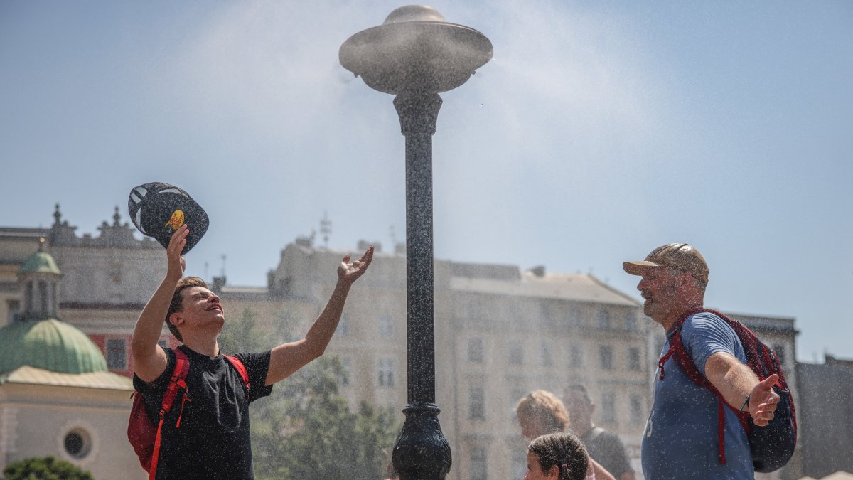 Personas se refrescan en medio de una ciudad por las altas temperaturas (Archivo)