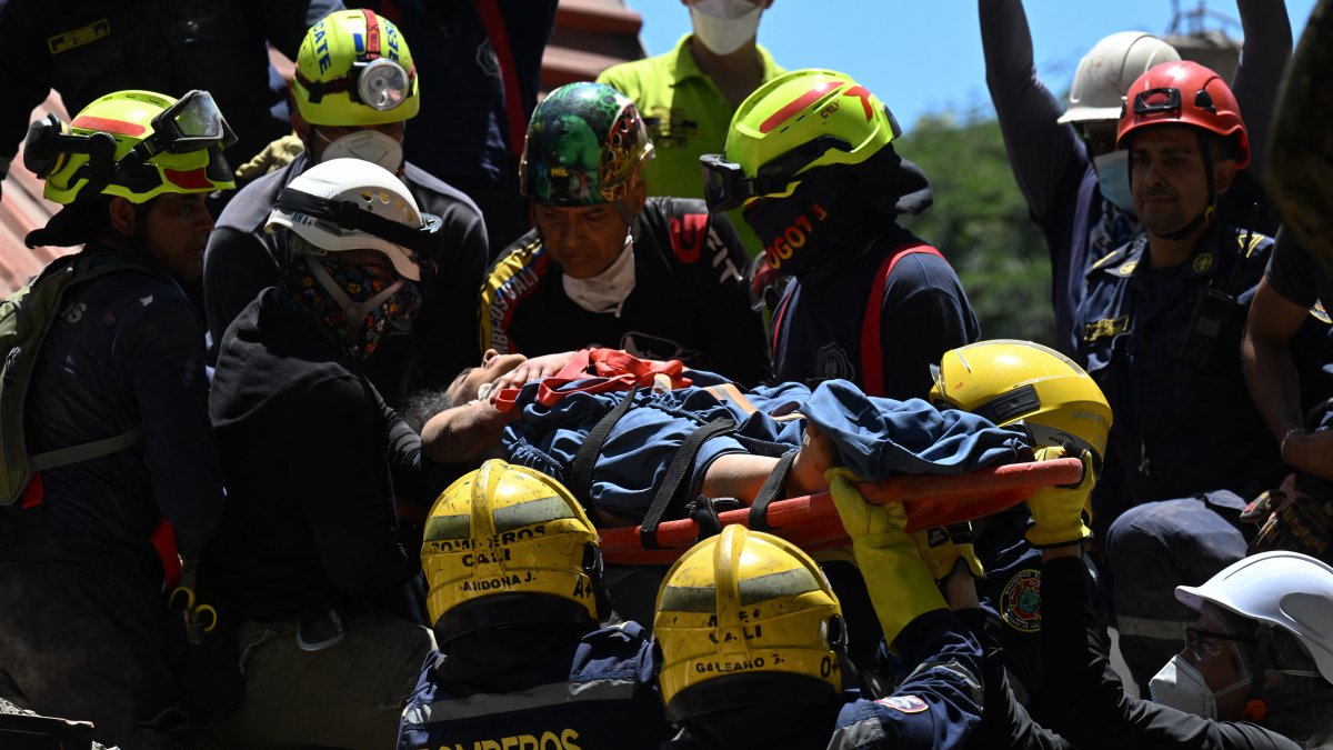 Colombian rescuers carry a person out of the rubble in Cali,