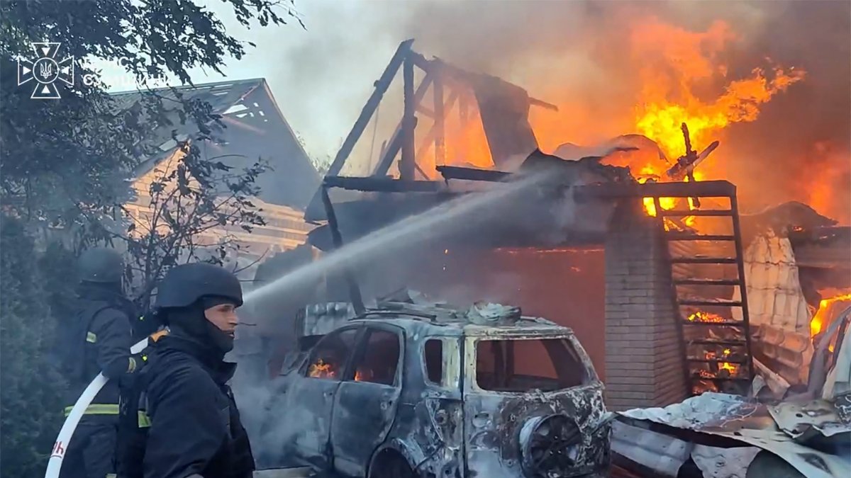 Ukrainian rescue workers battling a house fire following an airstrike
