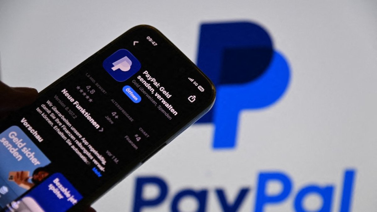 PayPal en la App Store frente a un monitor borroso con el logotipo de PayPal