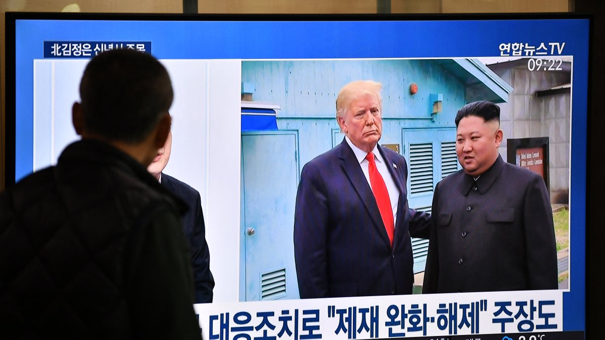 Un hombre observa por televisión la reunión entre Donald Trump y Kim Jong Un, el 1 de enero de 2020.