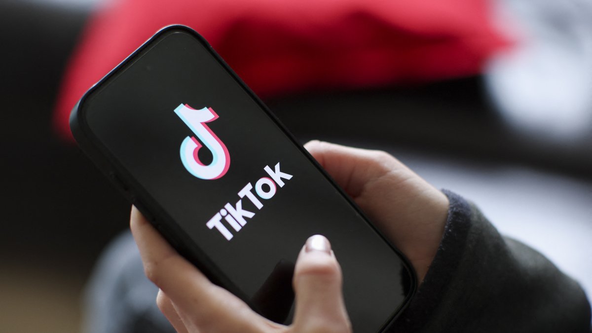 Una niña sostiene un iPhone 16 con el logotipo de la aplicación TikTok/ Jan Woitas