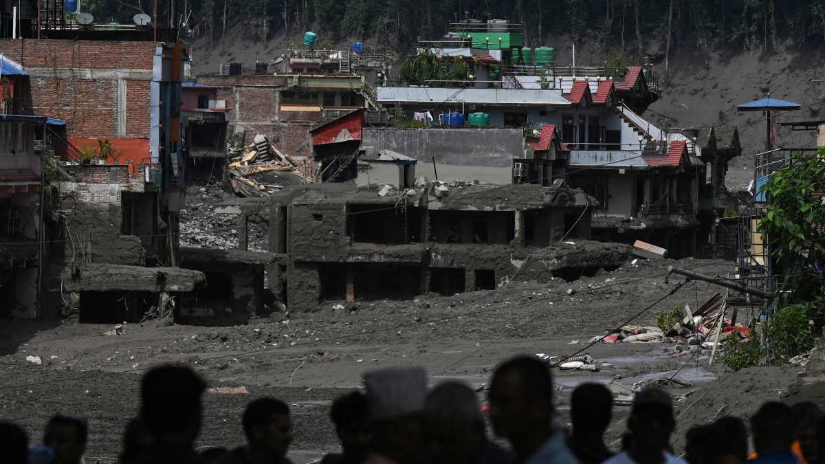 Residents of a Nepalese community search for their families after the flood
