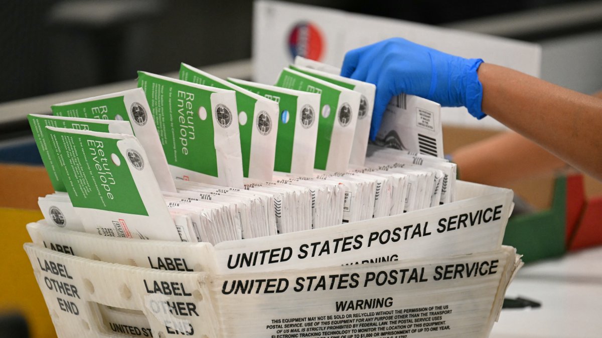 An election official processes mail-in ballots at the Los Angeles County Vote Processing Center on June 2, 2026.