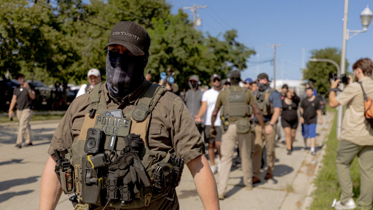 ICE agents confront protesters after they damaged a vehicle while attempting to detain a person in Chicago on August 24, 2026.