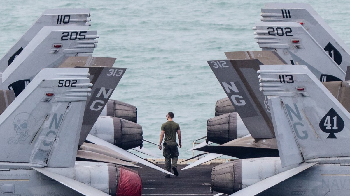 A crew member walks on the deck of the U.S. nuclear-powered aircraft carrier USS Abraham Lincoln