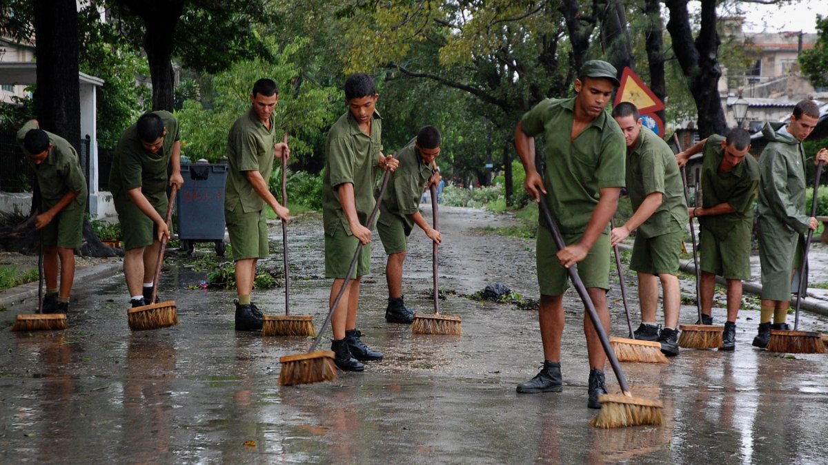 Cuban recruits sweep a street in Havana in 2008 after the devastating Hurricane Ike