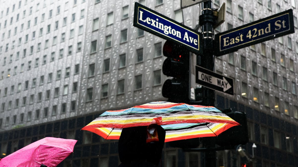 Several people walk in the rain near Grand Central Terminal in New York