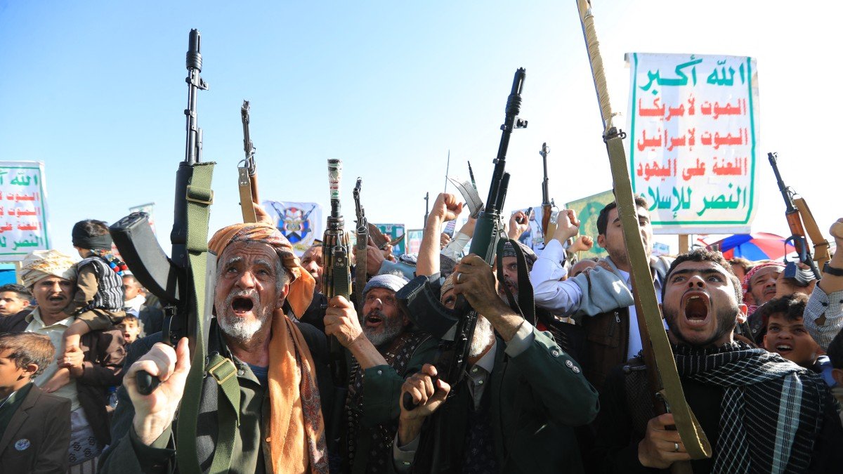 Supporters of the Houthi authorities display their weapons during a protest against the Saudi authorities