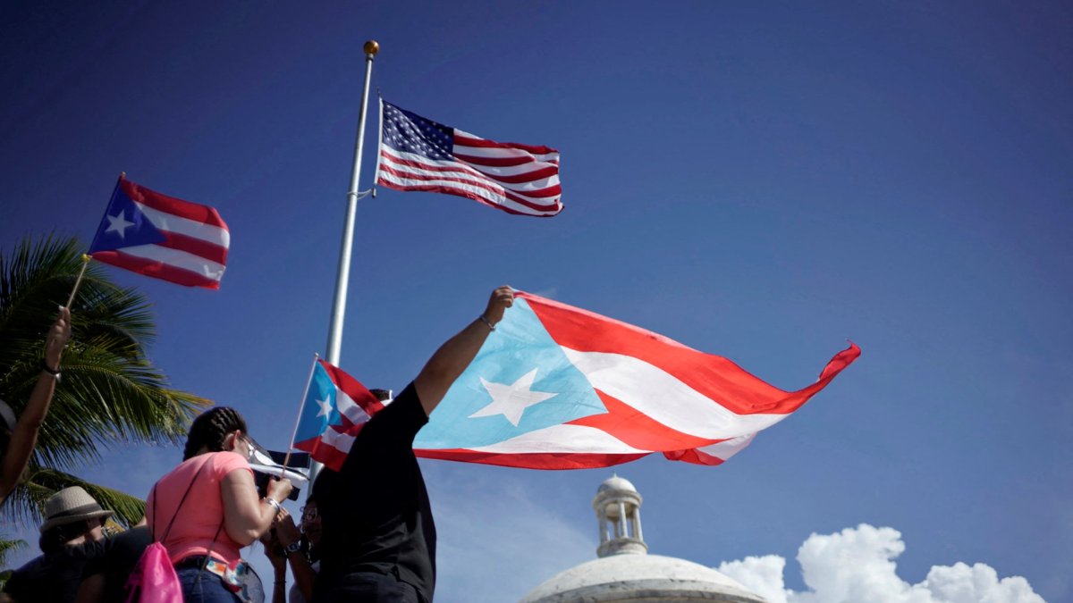 Imagen de archivo y de referencia que muestran manifestantes con la bandera de Puerto Rico