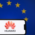 Esta fotografía ilustrativa tomada en Bruselas el 13 de marzo de 2025 muestra el logotipo del gigante chino de las telecomunicaciones Huawei en un smartphone delante de una bandera de la Unión Europea. La policía belga allanó varios domicilios en el país en el marco de una investigación sobre presunta corrupción "bajo la apariencia de lobby comercial", informó la fiscalía. "Varias personas han sido detenidas para ser interrogadas en relación con su presunta implicación en corrupción activa", dijo la fiscalía federal, añadiendo que también se llevaron a cabo registros en Portugal. El periódico belga Le Soir dijo que la investigación estaba relacionada con el gigante tecnológico chino Huawei y sus actividades en Bruselas desde 2021.
