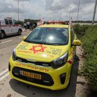 Los servicios de emergencia médica israelíes esperan en una carretera salpicada de barro a las afueras del aeropuerto israelí Ben Gurion tras el impacto de un misil cerca de las instalaciones el 4 de mayo de 2025.