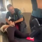 A Spanish police officer arresting a woman in Valencia