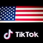 El logotipo de TikTok se muestra en un smartphone junto a la bandera de Estados Unidos. TikTok es una aplicación lanzada en 2016 por ByteDance, una empresa tecnológica china.