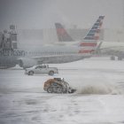 A snow plow works to clear the runways at Logan Airpot in Boston, Massachusetts, on January 25, 2026. A massive winter storm on January 24 dumped snow and freezing rain from New Mexico to North Carolina as it swept across the United States towards the northeast, threatening tens of millions of Americans with blackouts, transportation chaos and bone-chilling cold. After battering the country's southwest and central areas, the storm system began to hit the heavily populated mid-Atlantic and northeastern states as a frigid air mass settled in across the nation. (Photo by Joseph Prezioso / AFP)