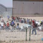 Migrantes en fila intentando cruzar la frontera entre Estados Unidos y México.