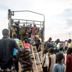 Personas que huyen de la guerra sudanesa desembarcan de un camión que las ha traído a Renk desde el paso fronterizo de Joda, en Sudán del Sur.