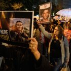 Mujeres israelíes marchan mientras sostienen carteles con las fotos de los rehenes israelíes Noa Argamani y Oz Daniel durante una manifestación en Tel Aviv en demanda de un acuerdo inmediato sobre los rehenes y un alto el fuego.