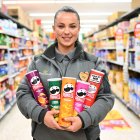 EDITORIAL USE ONLY Team member at Morrisons Stratford, Angela holds tubs of Pringles as the supermarket launches a new deal on the crisps for More Card holders. Issue date: Wednesday September 12, 2023.