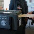 Elecciones presidenciales 2024: Un votante introduce su papeleta en la urna oficial en uno de los centros de votación anticipada de San Diego.