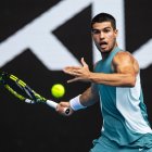 Carlos Alcaraz da un revés de raqueta durante su partido contra Yoshihito Nishioka durante el Open de Australia