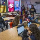 Alumnos asisten a la clase de historia impartida por Jacob Marsh en la Mark Twain Middle School de Alexandria, Virginia, el 6 de marzo de 2025, sin teléfonos inteligentes debido a la prohibición. La prohibición de los teléfonos en la escuela forma parte de una oleada de medidas aplicadas en todo Estados Unidos y de un movimiento mundial que se repite en Brasil, Francia y otros países. Los partidarios creen que las restricciones protegerán a los alumnos de los aparentes perjuicios del uso de teléfonos inteligentes mientras están en la escuela, pero los detractores afirman que las medidas no preparan a los adolescentes para el mundo digital en el que inevitablemente entrarán. (Foto de Jim WATSON / AFP)