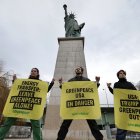 France's Greenpeace activists perform an action to support Greenpeace USA, next to Statue of Liberty at Pont de Grenelle in Paris on February 20, 2025. Energy Transfer, the Big Oil company behind the Dakota Access Pipeline, is suing Greenpeace USA for $300 million. (Photo by Thibaud MORITZ / AFP)