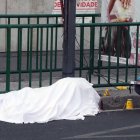 Un trabajador forense toma notas junto al cuerpo de José Muñoz en la escena del crimen del asesinato de Muñoz y Ximena Guzmán en Ciudad de México el 20 de mayo de 2025.