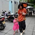 Una madre con su hija pequeña de la mano en Hanoi