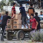 Personas transportan suministros de ayuda de la Fundación Humanitaria de Gaza (FGH)