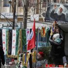 Un joven druso cuelga la imagen de Hikmat al-Hijri, líder espiritual de su comunidad en Siria