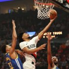El escolta de los Portland Trail Blazers, Shaedon Sharpe (17), penetra hacia la canasta entre el alero de los Golden State Warriors, Trayce Jackson-Davis (32), y el escolta Moses Moody (4) durante la primera mitad de un partido de baloncesto de la NBA el viernes 24 de octubre de 2025 en Portland, Oregón. (AP Photo/Amanda Loman)