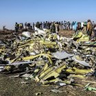 Personas se encuentran cerca de los escombros recogidos en el lugar del accidente de Etiopía Airlines cerca de Bishoftu