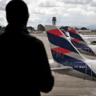Un pasajero venezolano mira un avión de LATAM (Archivo)
