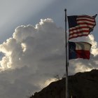 La bandera de los Estados Unidos y la bandera del estado de Texas se exhiben en el parque Murchison Rogers a lo largo de Scenic Drive al atardecer el 24 de junio de 2021 en El Paso, Texas.