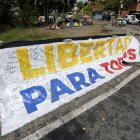 Una pancarta que dice "Libertad para todos" se exhibe frente a la prisión El Rodeo I en Guatire